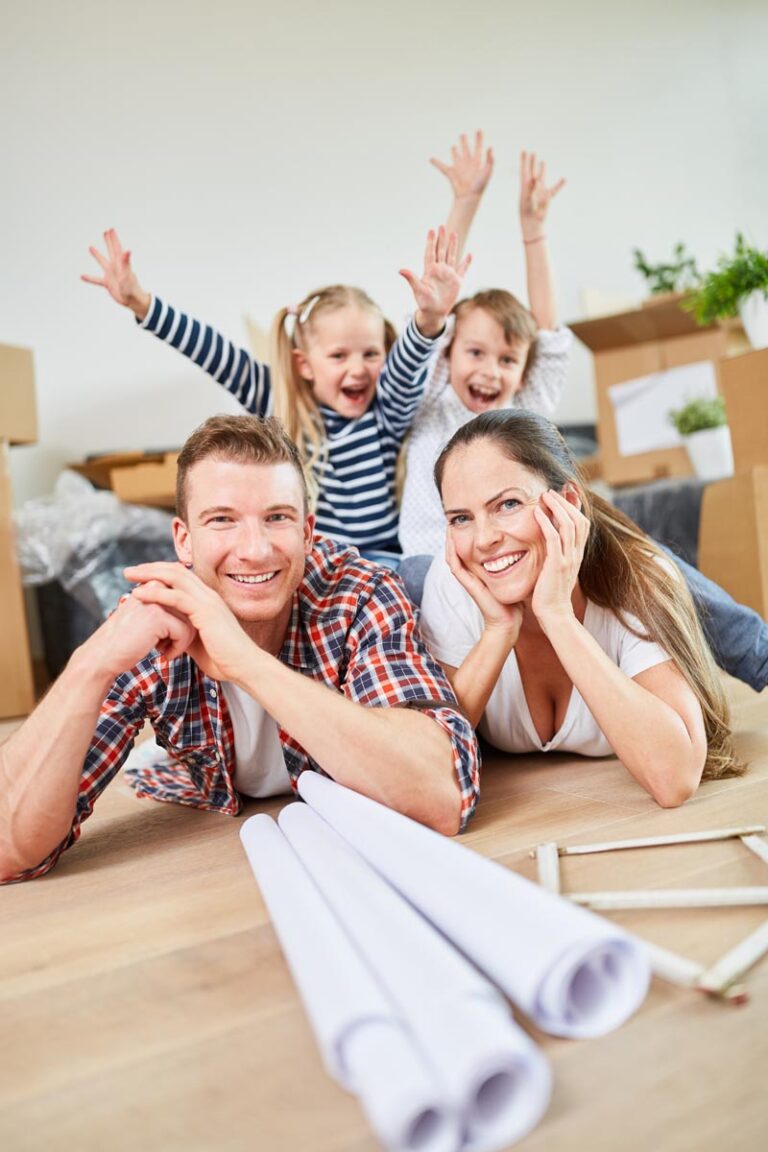 Referenzbild von einer jungen Familie mit zwei Kindern die in einem Holzhaus auf dem Boden liegen in der Nähe von Köln.